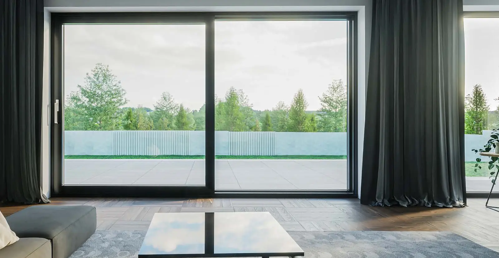 Hebeschiebetür in Anthrazit über die ganze Zimmerbreite, die Laufschiene liegt bündig im Boden, dahinter eine Dachterrasse